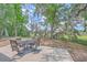 Backyard patio features an outdoor dining table, surrounded by mature trees at 2340 Ashley River Rd, Charleston, SC 29414