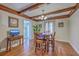 Dining room showing wood beam ceiling, hardwood flooring, wooden table, and television console at 2340 Ashley River Rd, Charleston, SC 29414