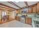 Bright kitchen adjacent to dining room showing granite countertops, wood cabinets, and stainless appliances at 2340 Ashley River Rd, Charleston, SC 29414
