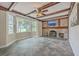 Bright living room featuring bay windows, brick fireplace, exposed wood beam ceiling, and slate tile floors at 2340 Ashley River Rd, Charleston, SC 29414