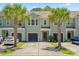 Inviting townhome with a well-kept lawn and beautiful palm trees enhancing its curb appeal at 2488 Stadium Dr, North Charleston, SC 29406