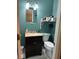 Modern bathroom with teal walls, mirror, vanity with sink and white tiled floors at 277 Carolina Cir, Walterboro, SC 29488