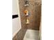 Bathroom shower with a brown tile surround, storage shelving and shower curtain at 277 Carolina Cir, Walterboro, SC 29488