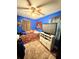 Cozy bedroom showcasing blue walls, a ceiling fan, a large TV, and neutral-colored carpets at 277 Carolina Cir, Walterboro, SC 29488
