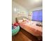 Bright bedroom featuring pink and gray color scheme, hardwood floors and a large window at 277 Carolina Cir, Walterboro, SC 29488