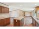 The kitchen with island has wood cabinets, granite countertops, and seamless flow to the dining and living areas at 282 Marion Rd, Dorchester, SC 29437