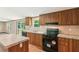 This kitchen has wood cabinets, granite countertops, and black appliances overlooking an outdoor deck at 282 Marion Rd, Dorchester, SC 29437