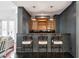 Stylish bar area with dark gray walls, accent lighting, custom cabinetry, and barstool seating at 3 Cross Ln, Isle of Palms, SC 29451