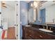 This powder bathroom features a blue accent wall and a double vanity with black countertop at 3 Cross Ln, Isle of Palms, SC 29451