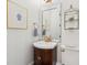 Elegant powder room with patterned mirror, stylish sink with bronze fixtures, and decorative accents at 3 Cross Ln, Isle of Palms, SC 29451