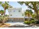 Stunning three-story home featuring a three-car garage, multiple balconies, and lush palm tree landscaping at 3 Cross Ln, Isle of Palms, SC 29451