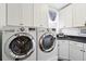 Bright laundry room features new front loading washer and dryer and storage at 3 Cross Ln, Isle of Palms, SC 29451