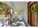 Long covered front porch with rocking chairs, brick columns, and tiled floor at 3 Cross Ln, Isle of Palms, SC 29451