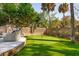 Private backyard putting green framed by mature trees and brick-lined fencing at 3 Cross Ln, Isle of Palms, SC 29451