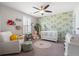 Bright Bedroom featuring leafy wallpaper, a white crib, neutral rug, and comfortable seating at 301 Dunlin Dr, Summerville, SC 29486