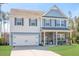 Charming two-story home with blue and white siding, attached garage, and well-manicured lawn at 301 Dunlin Dr, Summerville, SC 29486