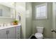 Charming powder room with a modern vanity, light grey cabinets, and a decorative mirror at 301 Dunlin Dr, Summerville, SC 29486