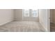 Bright, carpeted bedroom features natural light from two windows and a closet at 304 Pathfinder Way, Charleston, SC 29492