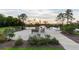 Scenic pond view with benches, fountain, and walkway under a tranquil, sunset sky at 304 Pathfinder Way, Charleston, SC 29492