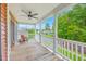Covered porch with white railing, wood flooring, ceiling fan, and outdoor seating area at 309 Harriswood Ln, Moncks Corner, SC 29461