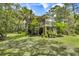 Spacious backyard featuring lush greenery, mature trees, and the home's exterior at 3627 Holmes Dr, Johns Island, SC 29455