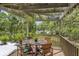 Cozy balcony with wooden table and chairs with green cushions, potted plants, and scenic outdoor view at 3627 Holmes Dr, Johns Island, SC 29455