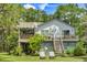 Two story home with open balcony, stairs, green lawn and patio chairs at 3627 Holmes Dr, Johns Island, SC 29455