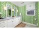 Bright bathroom with green patterned wallpaper, double vanity, and marble countertops at 37 Fort Royal Ave, Charleston, SC 29407