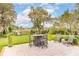 Landscaped backyard with dining set, patio, and views of the lake and dock at 4215 Ten Shillings Way, Ravenel, SC 29470