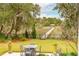 Landscaped backyard with patio, dining set, and private dock on the water at 4215 Ten Shillings Way, Ravenel, SC 29470