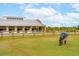 Horse property with a horse grazing in a lush field, complemented by a large barn and a tractor nearby at 4215 Ten Shillings Way, Ravenel, SC 29470