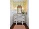Charming powder room boasts decorative wallpaper, an antique vanity and beautiful floral accents at 4215 Ten Shillings Way, Ravenel, SC 29470