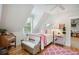 Charming bedroom with a sitting bench, light hardwood floors, and a sunny window at 4215 Ten Shillings Way, Ravenel, SC 29470