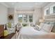 Bright bedroom with white walls and hardwood floors features a seating area next to a large bay window at 4215 Ten Shillings Way, Ravenel, SC 29470