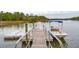 Waterfront home featuring a private dock with a boat, providing direct access to the water at 4215 Ten Shillings Way, Ravenel, SC 29470