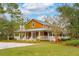 Charming home with a wrap-around porch, manicured lawn, and mature trees at 4215 Ten Shillings Way, Ravenel, SC 29470