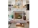 Close-up of a living room fireplace with a mantel, decorations, and shiplap walls at 4215 Ten Shillings Way, Ravenel, SC 29470