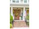 Charming front entrance with wooden door, brick steps, American flag and seasonal decorations at 4215 Ten Shillings Way, Ravenel, SC 29470