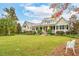 Charming home with a sprawling lawn, a covered porch, and mature trees at 4215 Ten Shillings Way, Ravenel, SC 29470