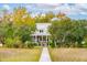 Picturesque waterfront home with a long dock and lush landscaping, offering serene coastal living at 4215 Ten Shillings Way, Ravenel, SC 29470