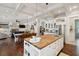 Open floor plan with kitchen island, stainless steel appliances, dining area, and fireplace at 4215 Ten Shillings Way, Ravenel, SC 29470