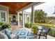 Spacious covered porch featuring a fireplace, outdoor seating, and stylish decor at 4215 Ten Shillings Way, Ravenel, SC 29470