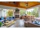 Inviting covered patio with a brick fireplace, comfortable seating, and a built-in bar at 4215 Ten Shillings Way, Ravenel, SC 29470