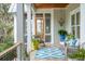 Charming porch with a patterned rug, wicker furniture, and wooden door entrance at 4215 Ten Shillings Way, Ravenel, SC 29470