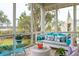 Cozy screened porch with swing, wicker table, and view of nature at 4215 Ten Shillings Way, Ravenel, SC 29470
