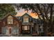 Charming two-story home featuring a brick facade, attached two-car garage, and inviting front porch with sunset skies at 482 Planters Trace Dr, Charleston, SC 29412