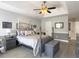 Main bedroom featuring a tray ceiling, ceiling fan, bedside lamps, and an en-suite bath creating a serene retreat at 482 Planters Trace Dr, Charleston, SC 29412