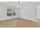 Bright bedroom boasts a large window, light hardwood floors and a modern chandelier at 4823 Shady Tree Ln, Summerville, SC 29485