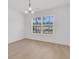 Bright empty room with wood floors, lots of natural light, and modern light fixture at 4823 Shady Tree Ln, Summerville, SC 29485