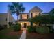 Charming two-story home with a well-manicured lawn and a beautiful palm tree at dusk at 4823 Shady Tree Ln, Summerville, SC 29485
